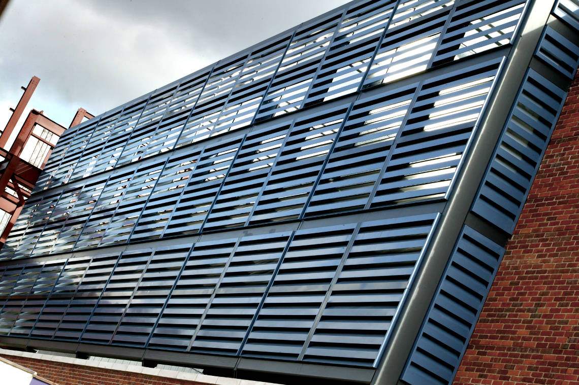 Acoustic cladding for reducing noise, installed at a parking garage