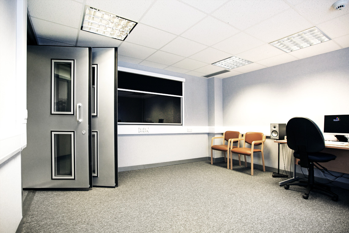 large audiometric sound room with two doors and window to the control room